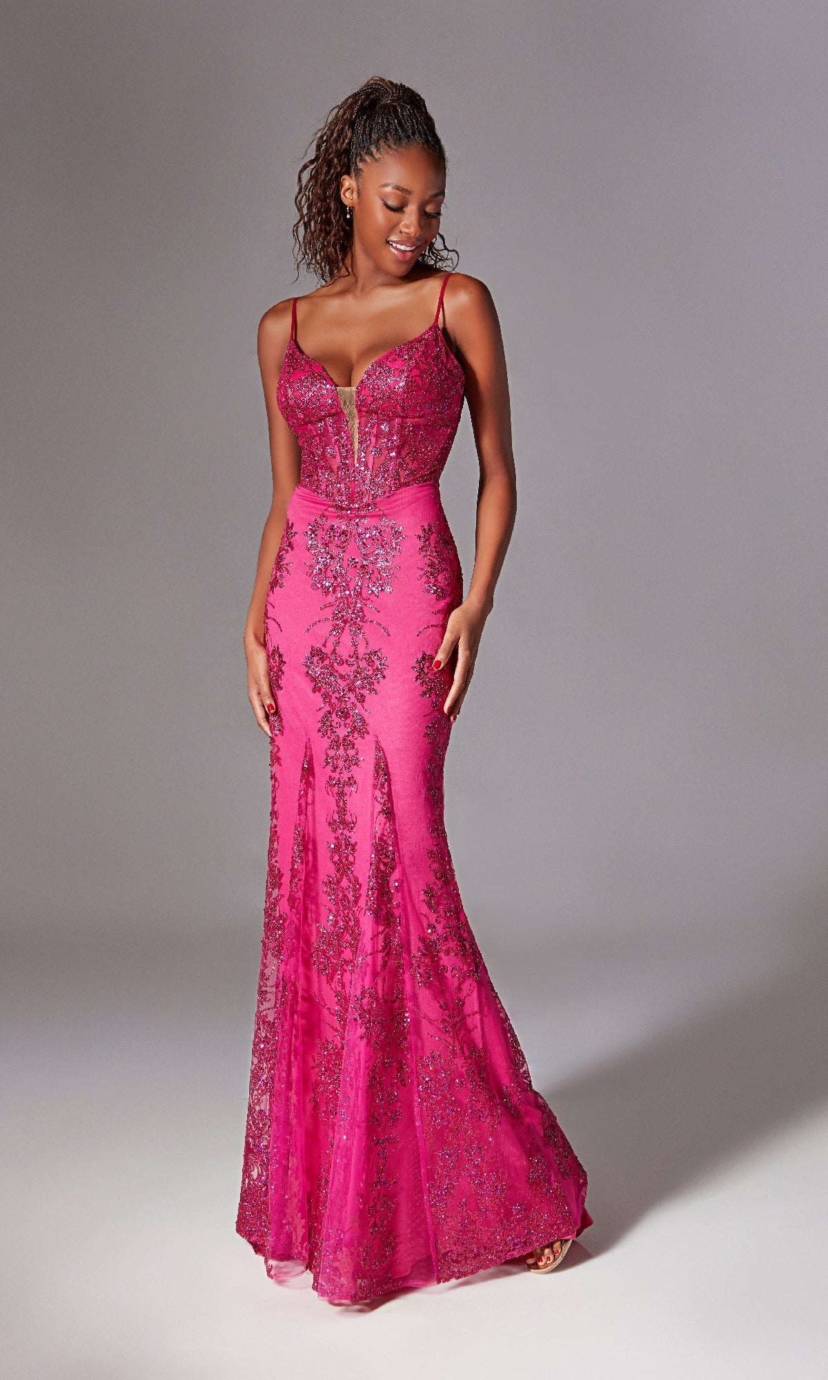 A woman models the Strappy-Back Long Prom Dress: Aerie Couture 206—a fitted, floor-length hot pink gown with beaded embellishments, thin straps, and a sheer corset-style bodice—against a plain background.
